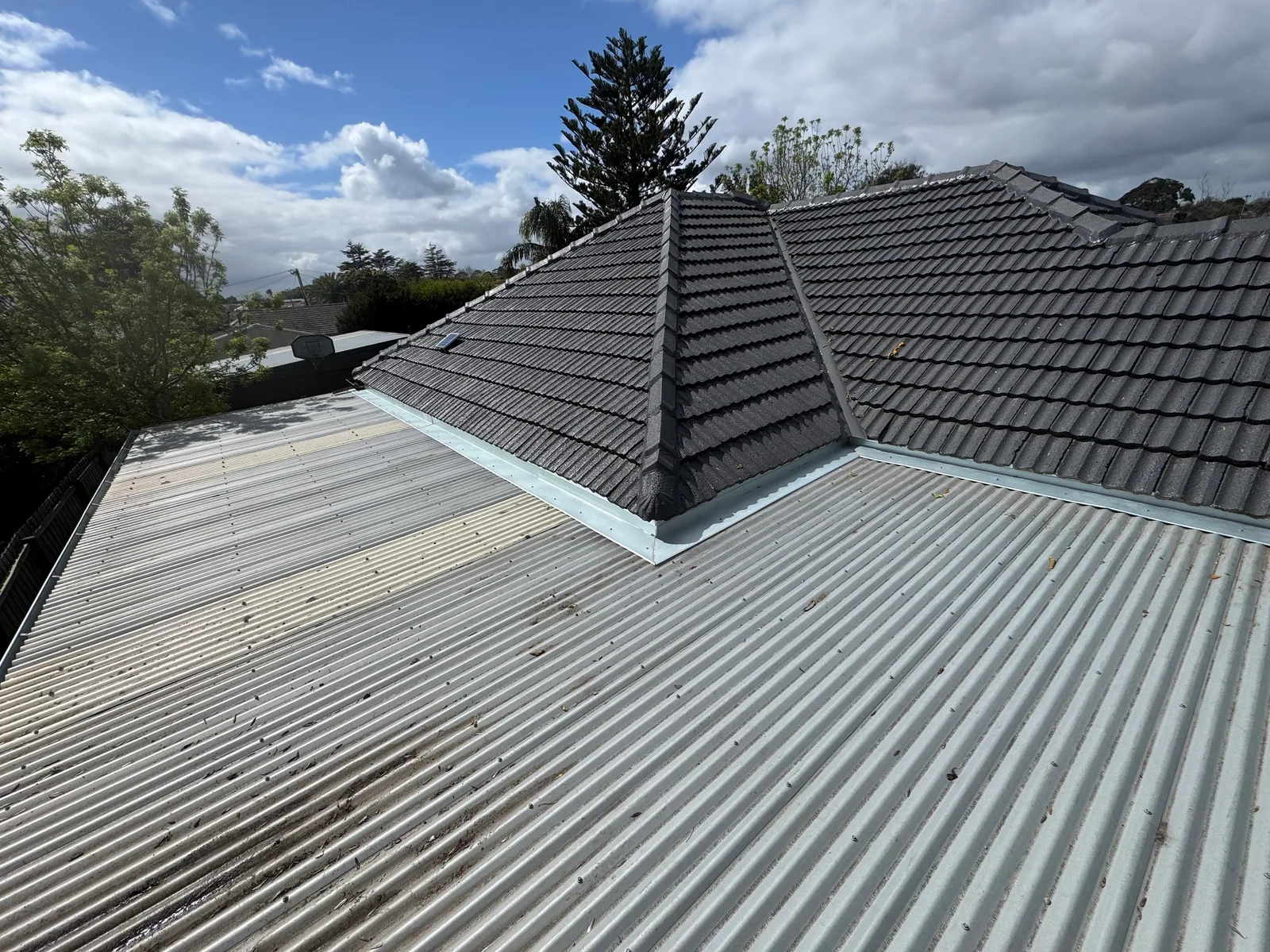 Box gutter and flashing installed by Quick2Fix on a suburban roof