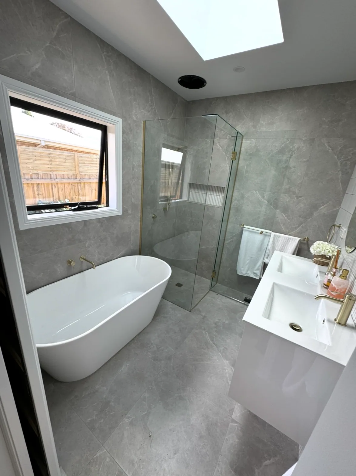 Renovated bathroom with freestanding bath, brass tapware and frameless shower — plumbing by Quick2Fix