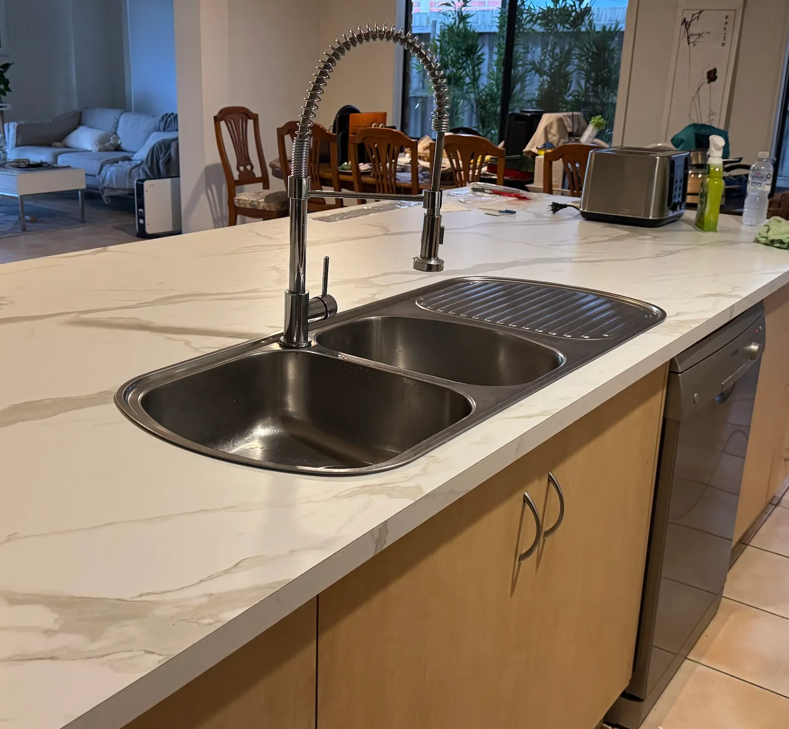 Kitchen island with new white marble-look benchtop, double-bowl stainless sink with drainer and a chrome pull-down spring mixer tap